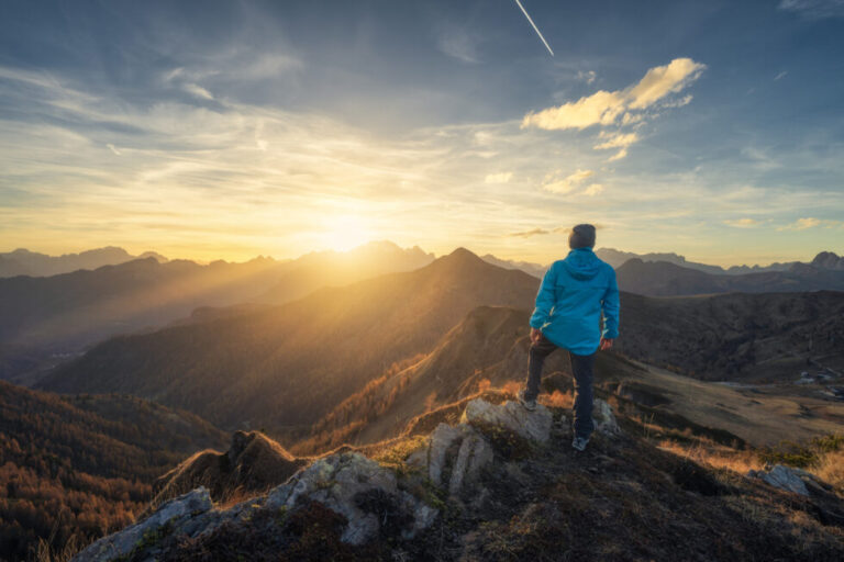 A man navigating the complex world of conversion pathways while standing on top of a mountain at sunset.