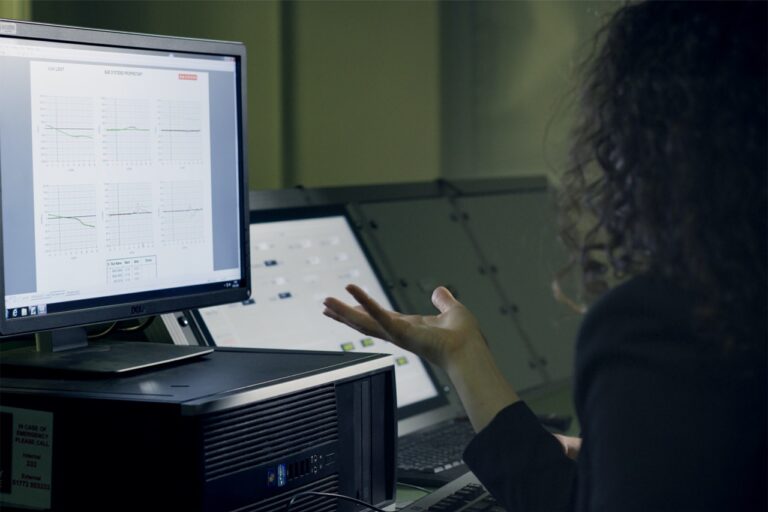 A woman is analyzing data on a computer screen.